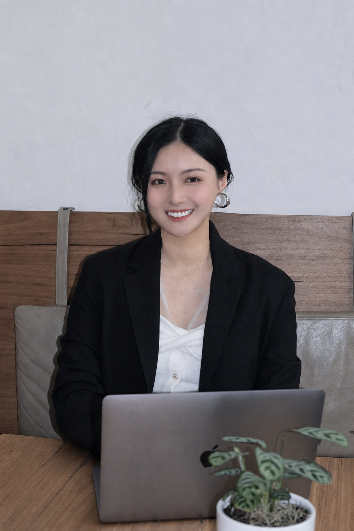 Lena 坐在工作室内的肖像,桌上放着电脑和绿植